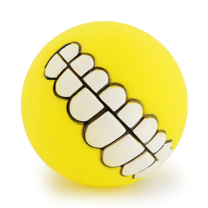 Yellow rubber pet teeth squeaky ball with white outlined tooth row detail.