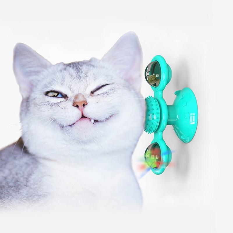 Teal scratch windmill cat toy with rotating pods and colorful light accents near cat