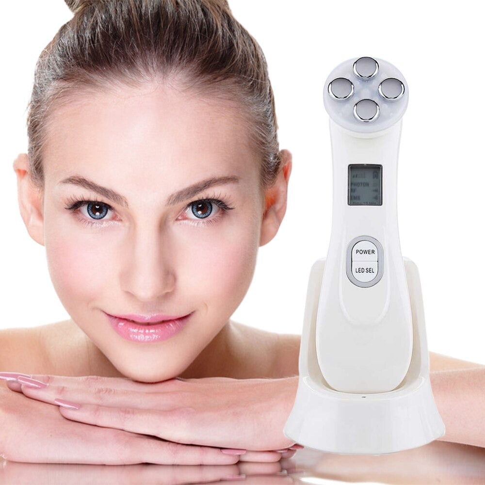 White face massager with purple electrode head next to face