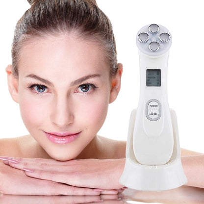 White face massager with purple electrode head next to face