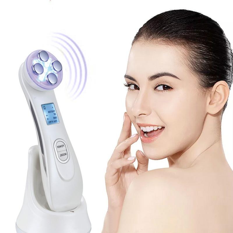 White face massager with purple electrode head held near cheek
