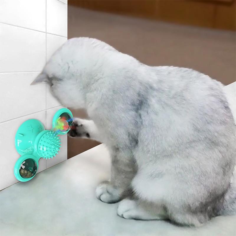 Turquoise scratch windmill cat toy with three light pods by a wall corner