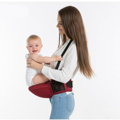 Hip seat carrier on waist with black straps, holding baby on the front.