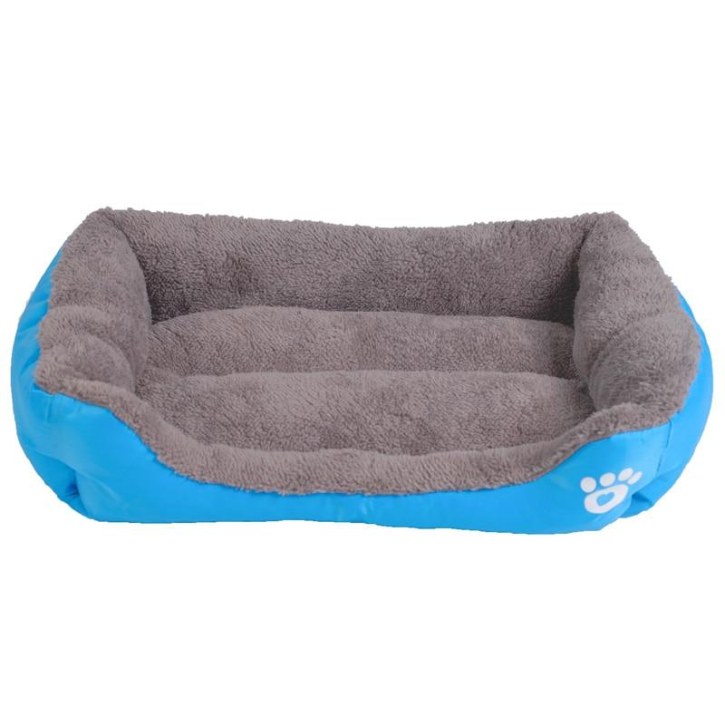 Waterproof fleece pet bed in blue with gray inner cushion and white paw-print patch