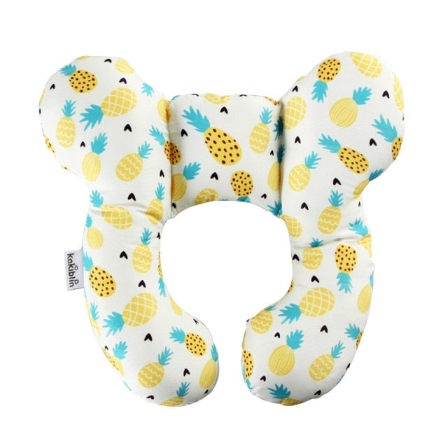 U-shaped baby head support pillow in cream with pineapple and cactus print, with kikidin tag