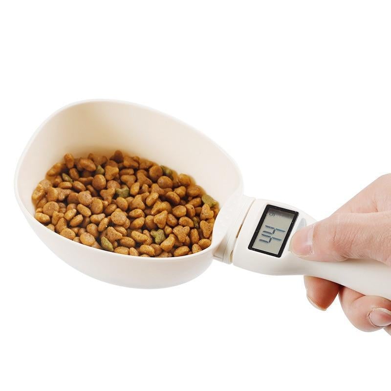 Digital measuring scoop with LCD screen, held with hand and filled with kibble