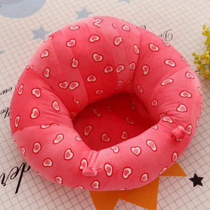 Baby sit-up support seat with red heart pattern cover and pink padded rings