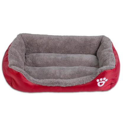 Waterproof fleece pet bed in red with gray inner cushion and white paw-print patch