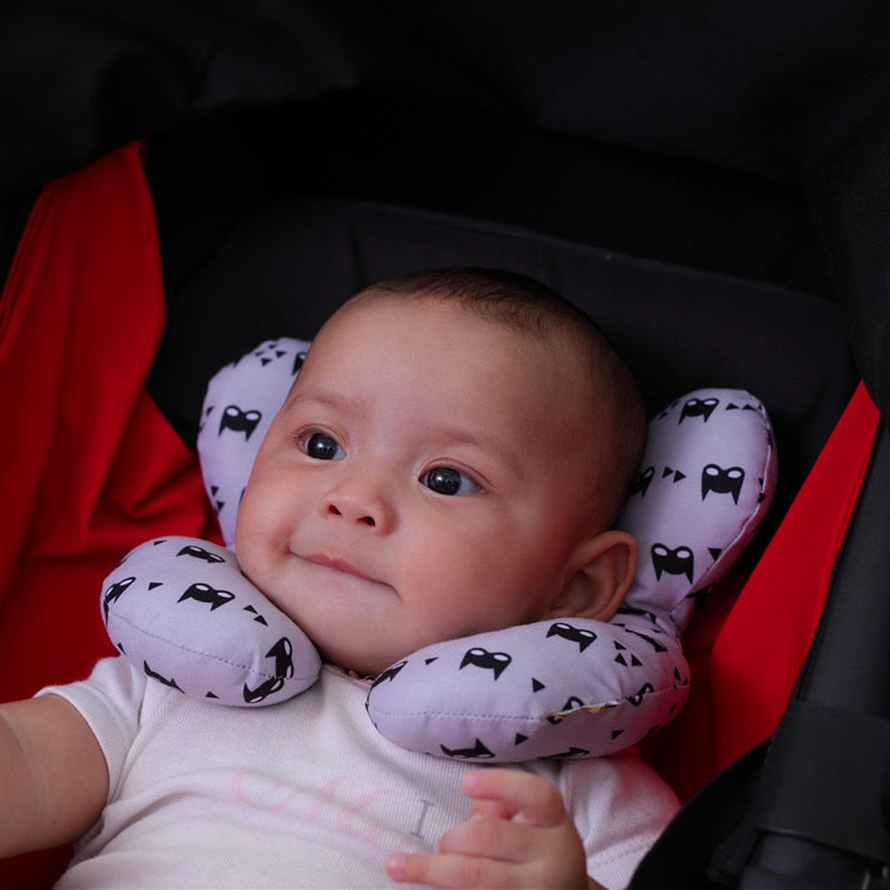 U-shaped baby head support pillow with white cover and black animal-silhouette pattern