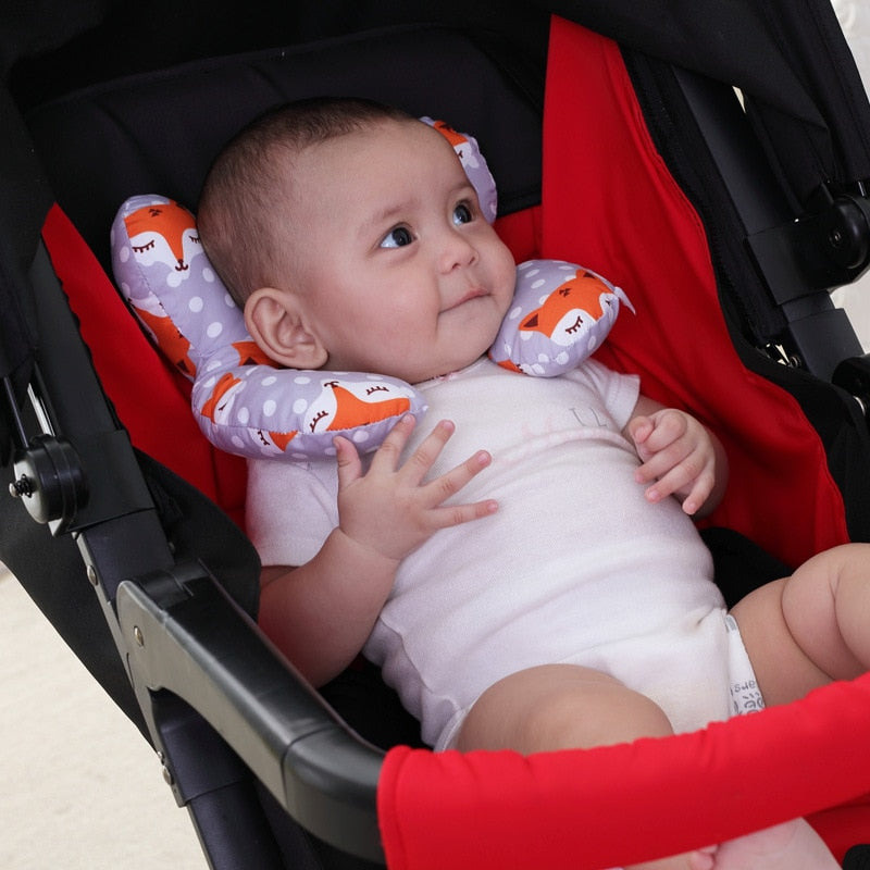 U-shaped baby head support pillow with fox pattern, secured in a stroller