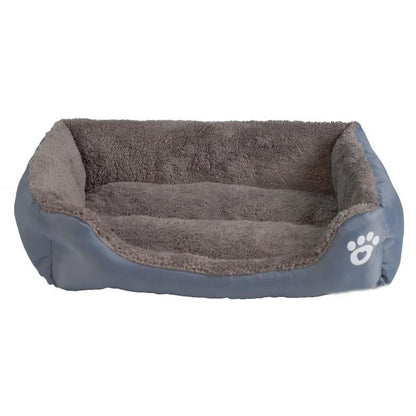 Waterproof fleece pet bed in blue with gray inner cushion and white paw-print patch